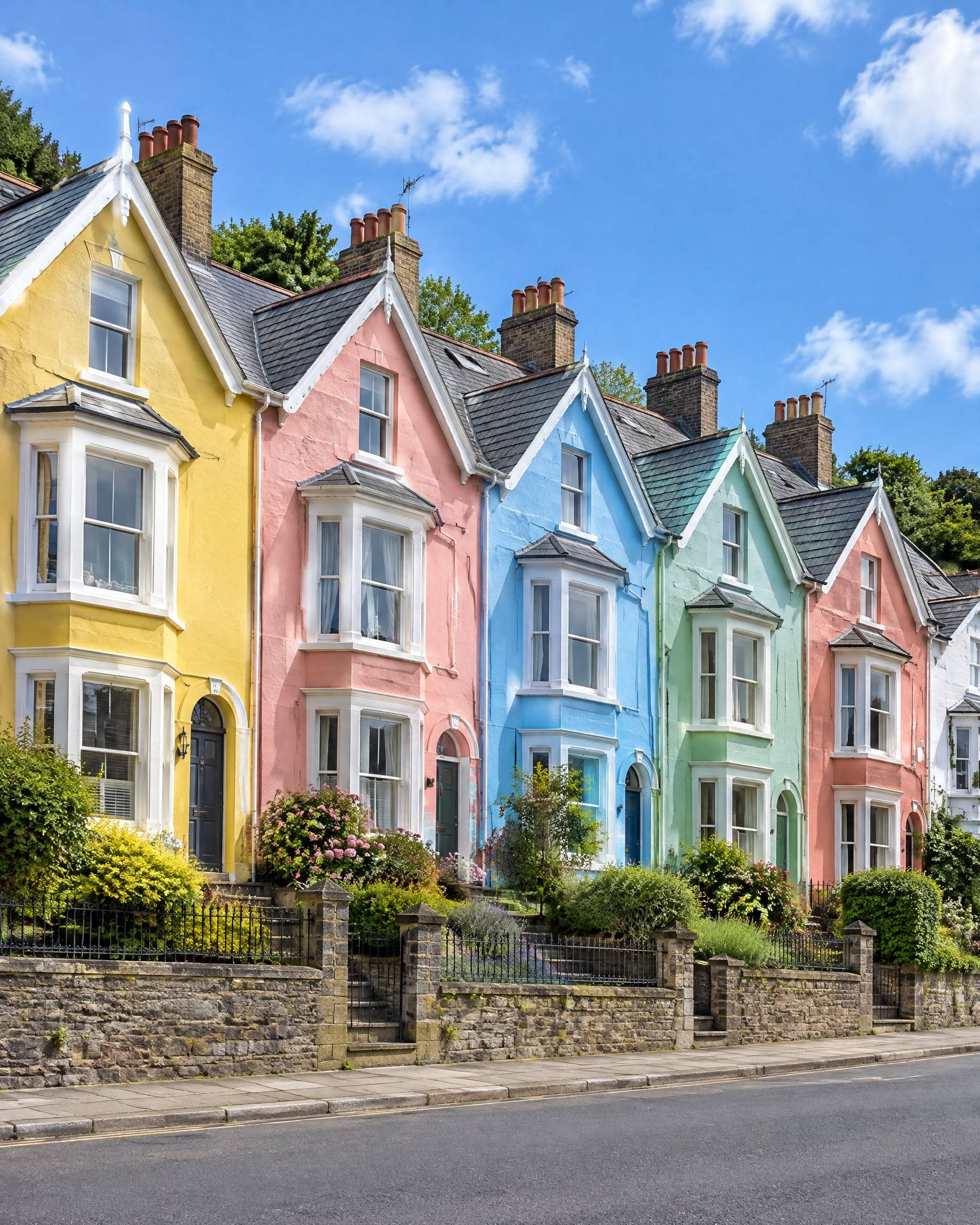 A row of Victorian terraces stepping up a hill in east Bristol, each painted a different bright colour