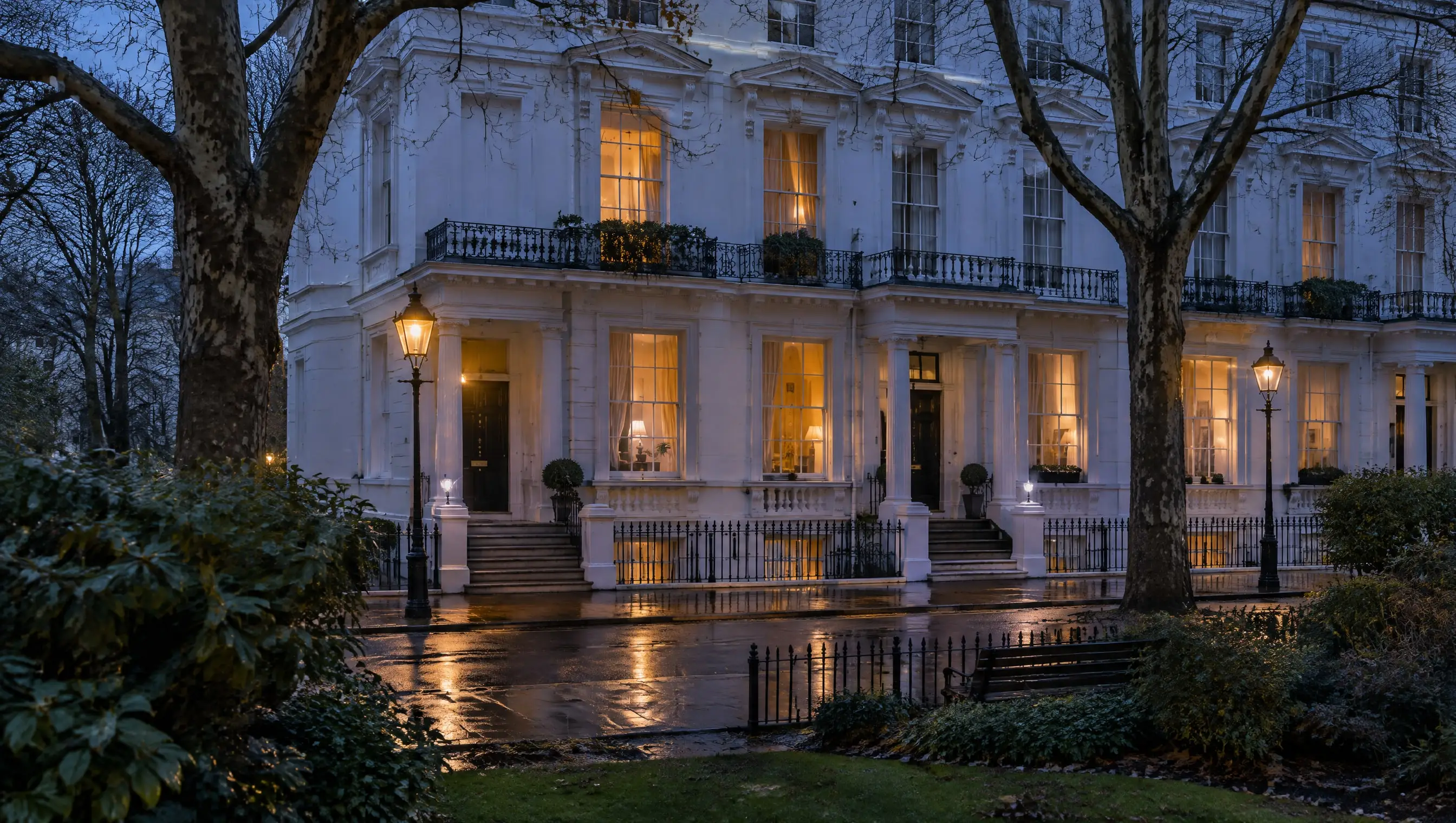A white stucco terrace on a South Kensington garden square at blue hour, its first floor windows lit (made for this demonstration)